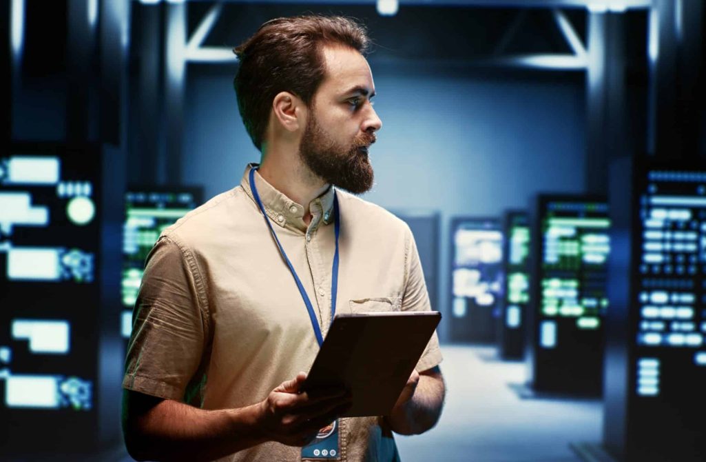Supervisor doing routine inspection, extending high tech facility equipment life span and avoiding downtime. Manager checking data center infrastructure units for power fluctuations